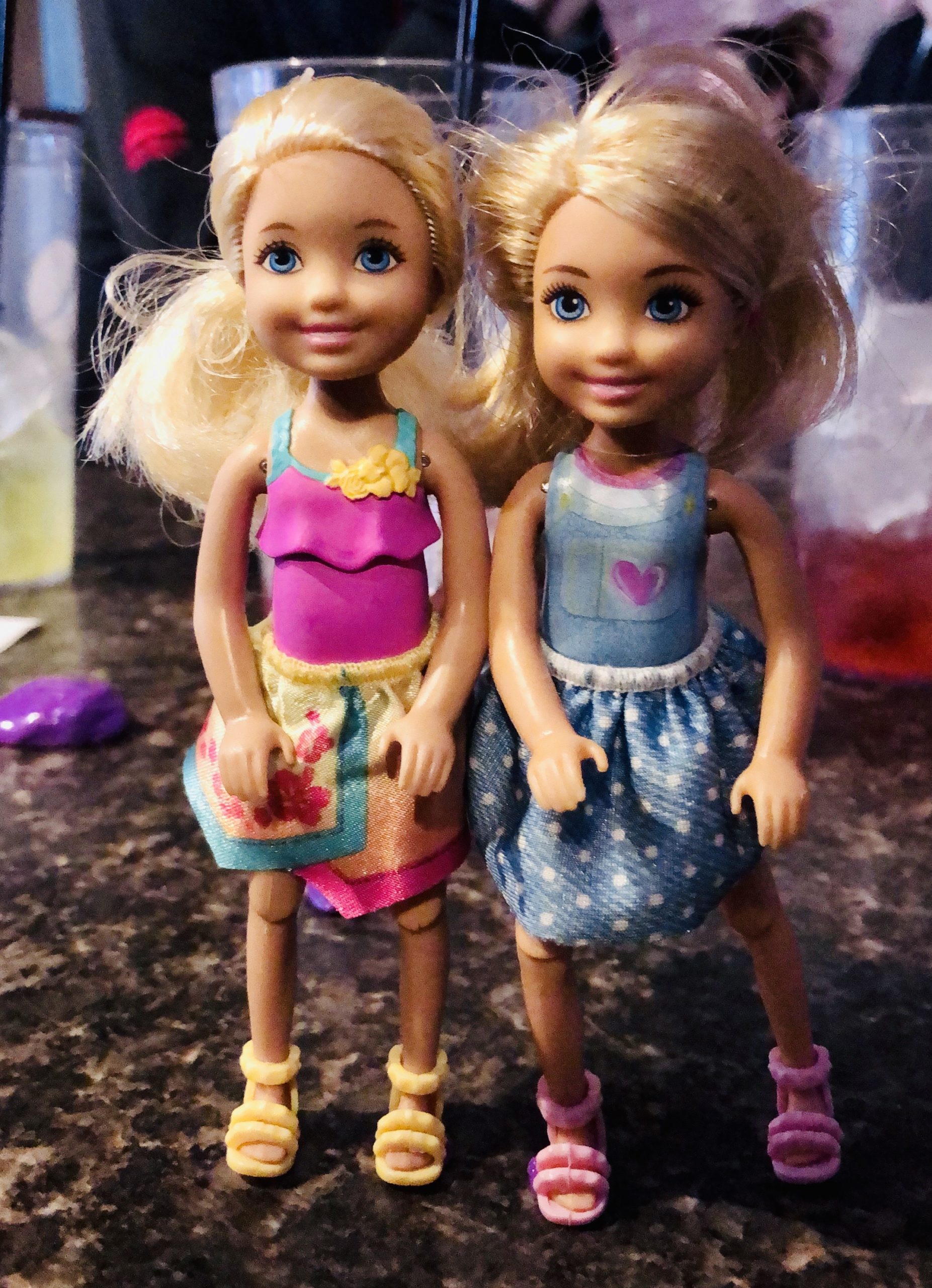 2 blonde haired Chelsea dolls named Brynn and Rowan for the short story Rowan's Diary.  One  is wearing a pink dress and the other has a blue dress on.