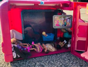 Barbies laying all over the pink Barbie Camper for the Barbie doll Story, Trekking to School.