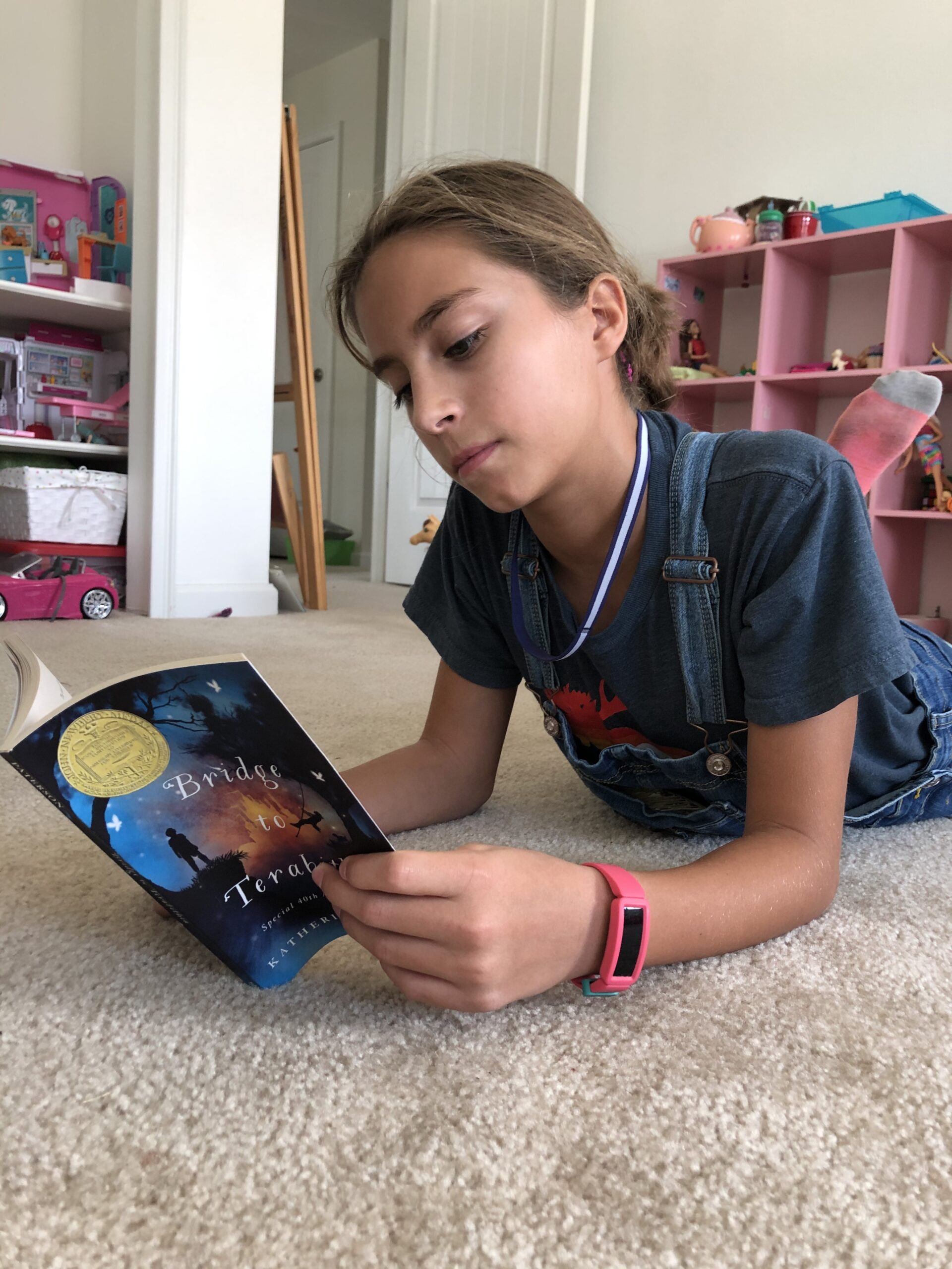 Girl reading Bridge to Terabithia for the children's book review.