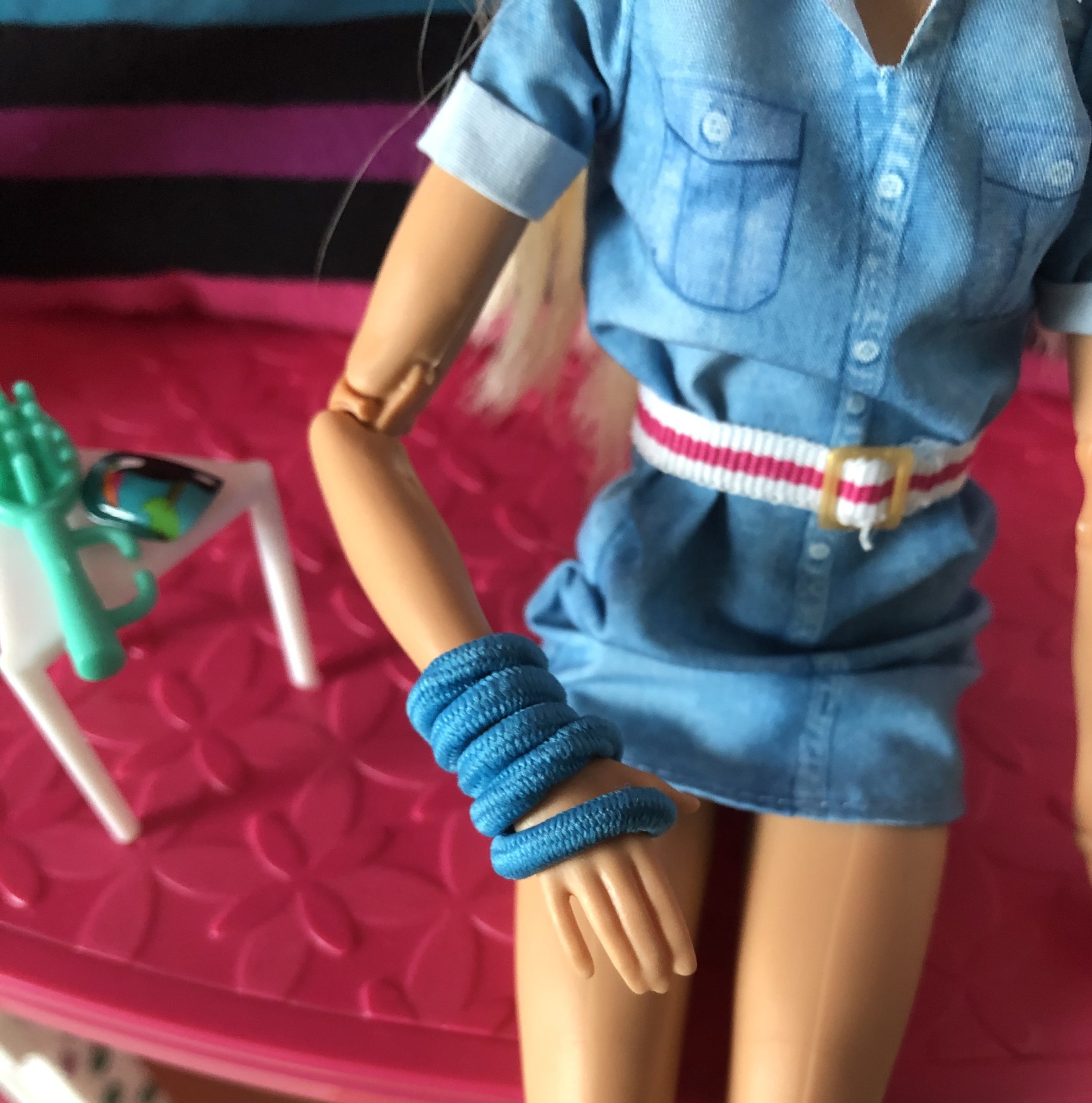 Barbie in a blue cast, which is really a ponytail holder.