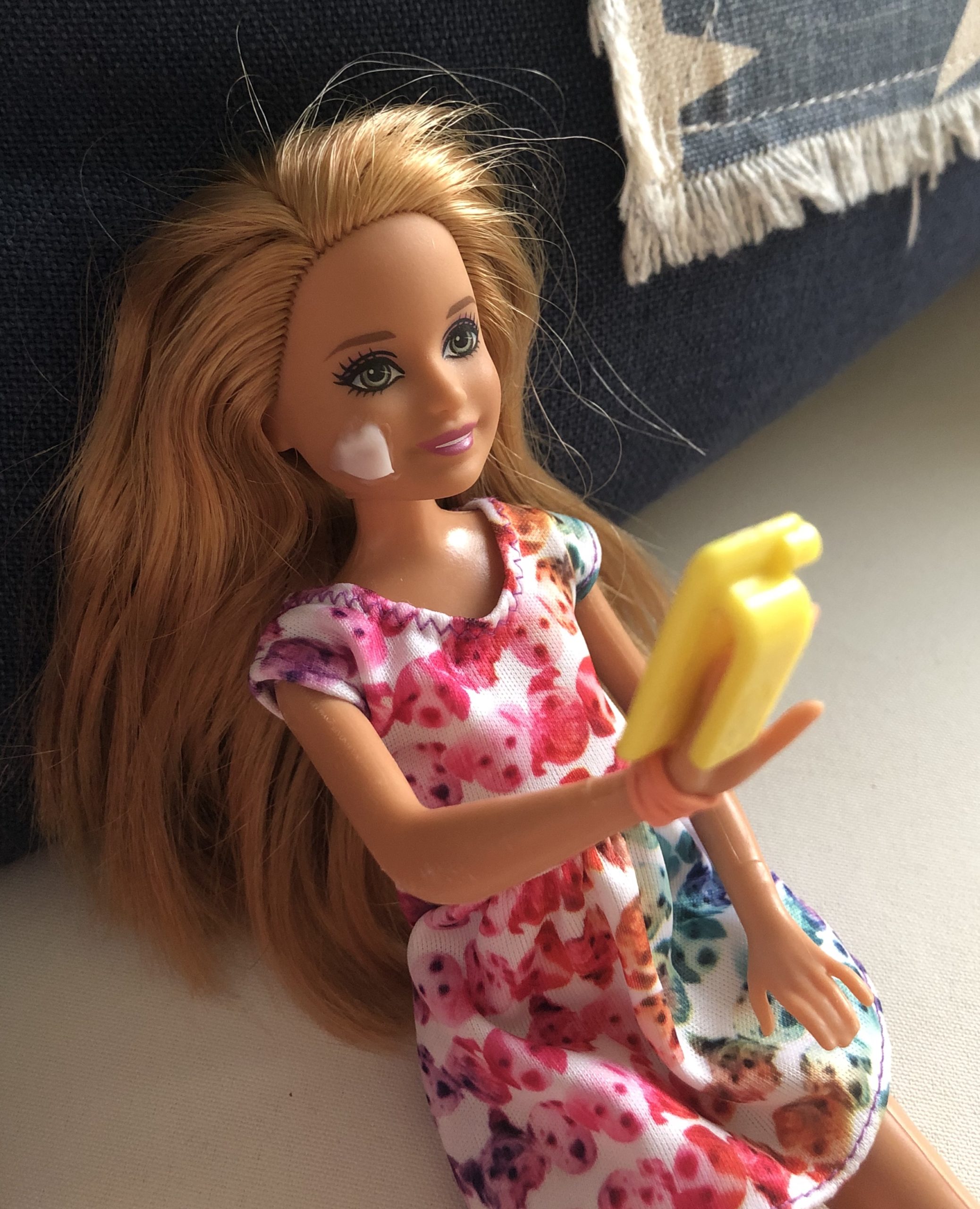 A Stacie doll holding a cell phone.