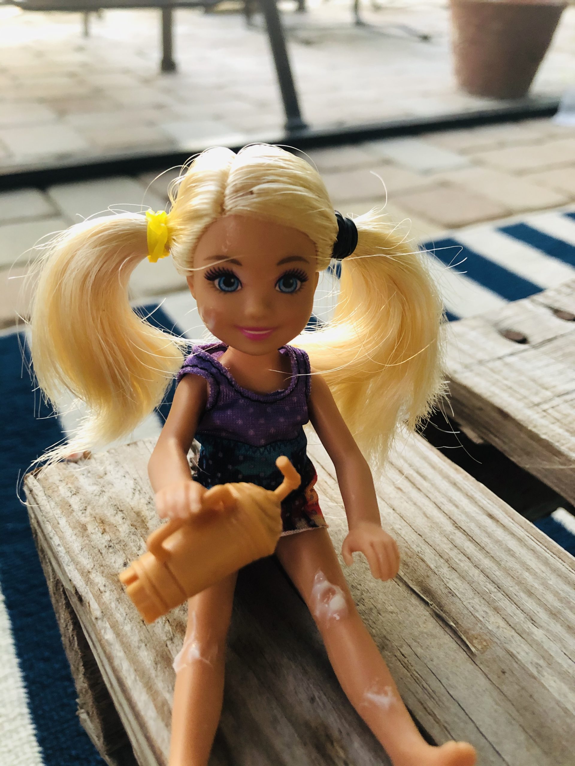 A Chelsea Barbie Doll holding a root beer float. She has blonde pigtails.