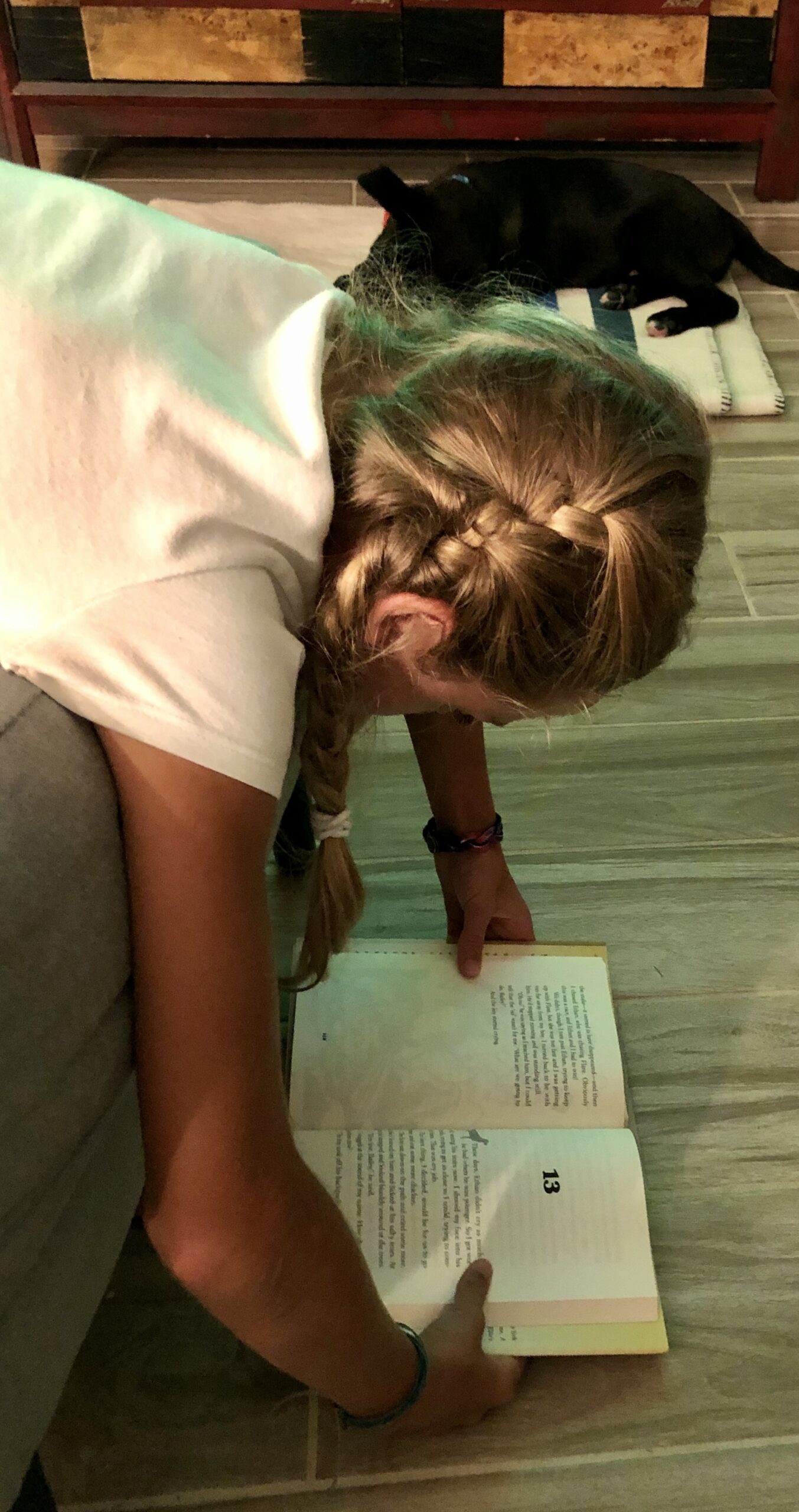 Girl reading Bailey's Story for the Book Review. She's hanging over a chair with the book on the floor.