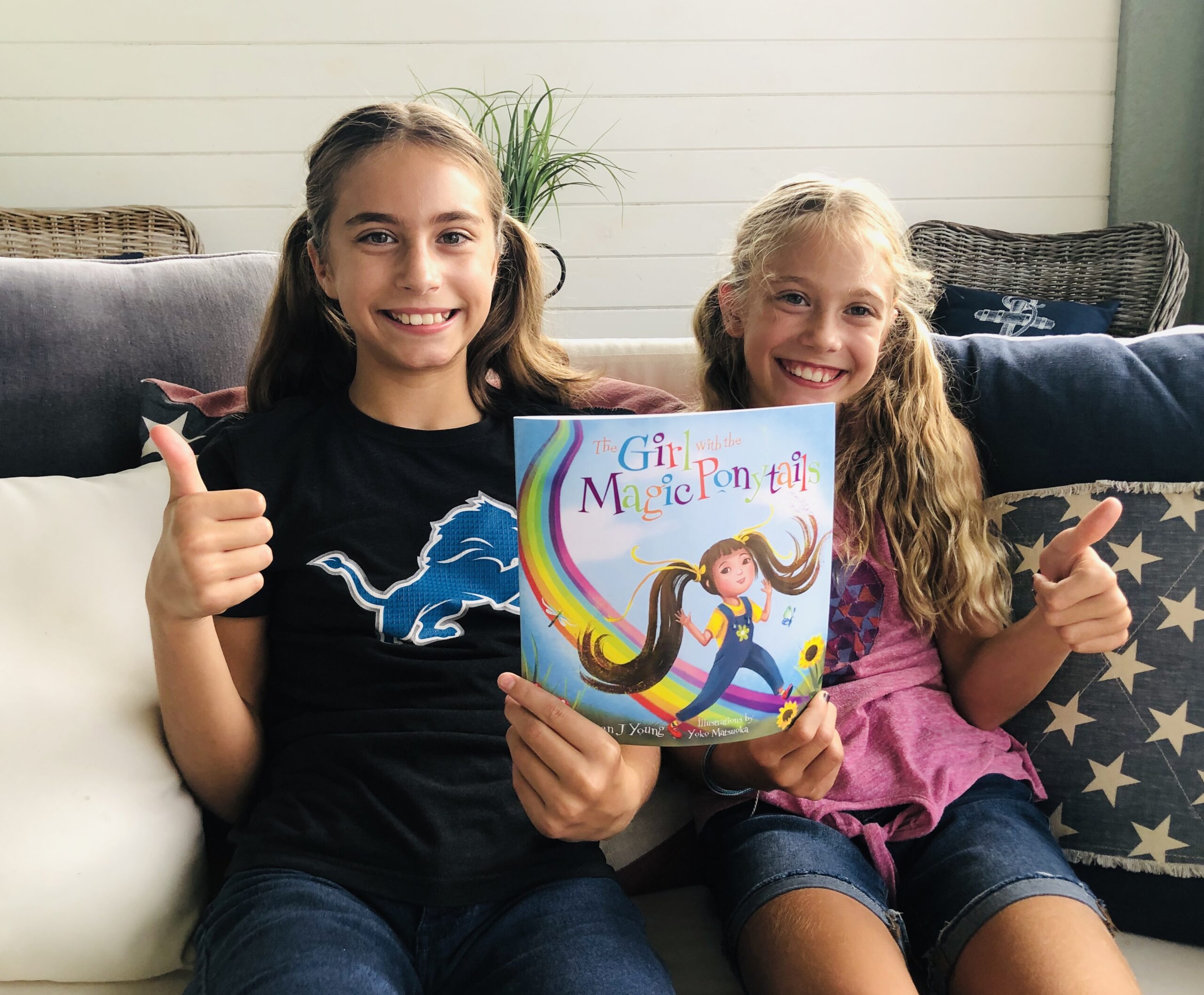 2 girls giving a thumbs up for a children's book review on The Girl with the Magic Ponytails.