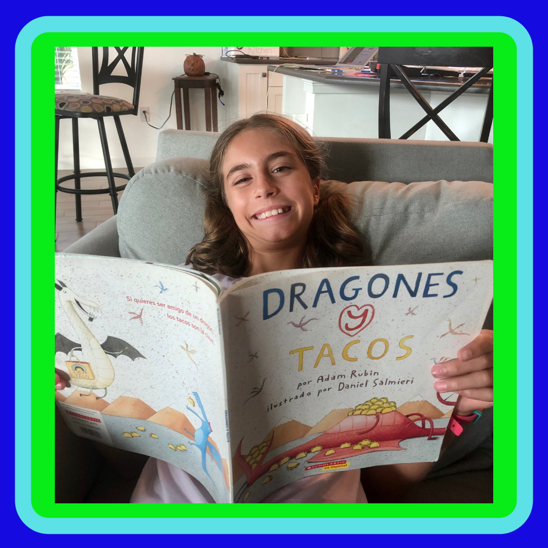 A girl reading Dragones y tacos or Dragons love Tacos for the children's book review.