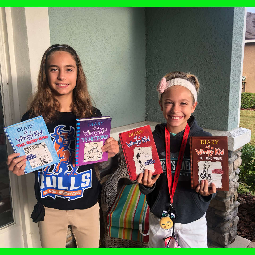 2 girls holding Diary of a Wimpy Kid Books.