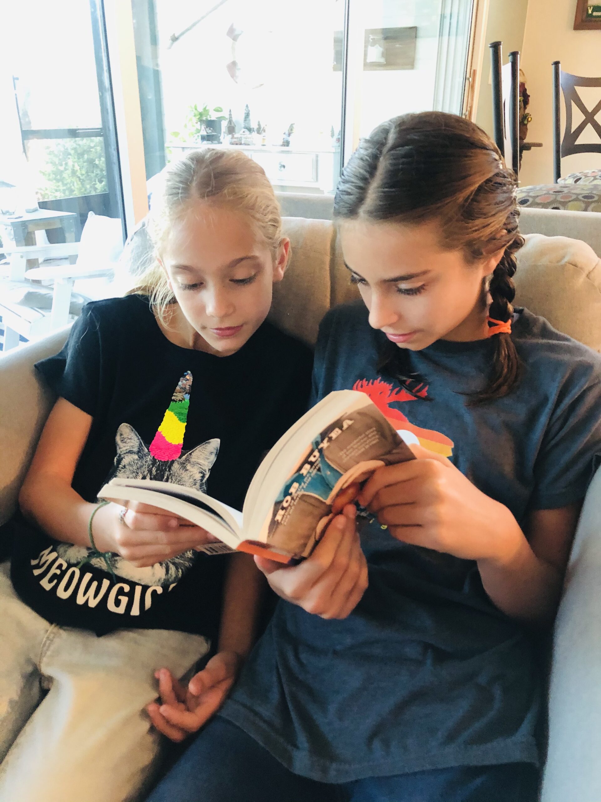 2 girls reading a book.