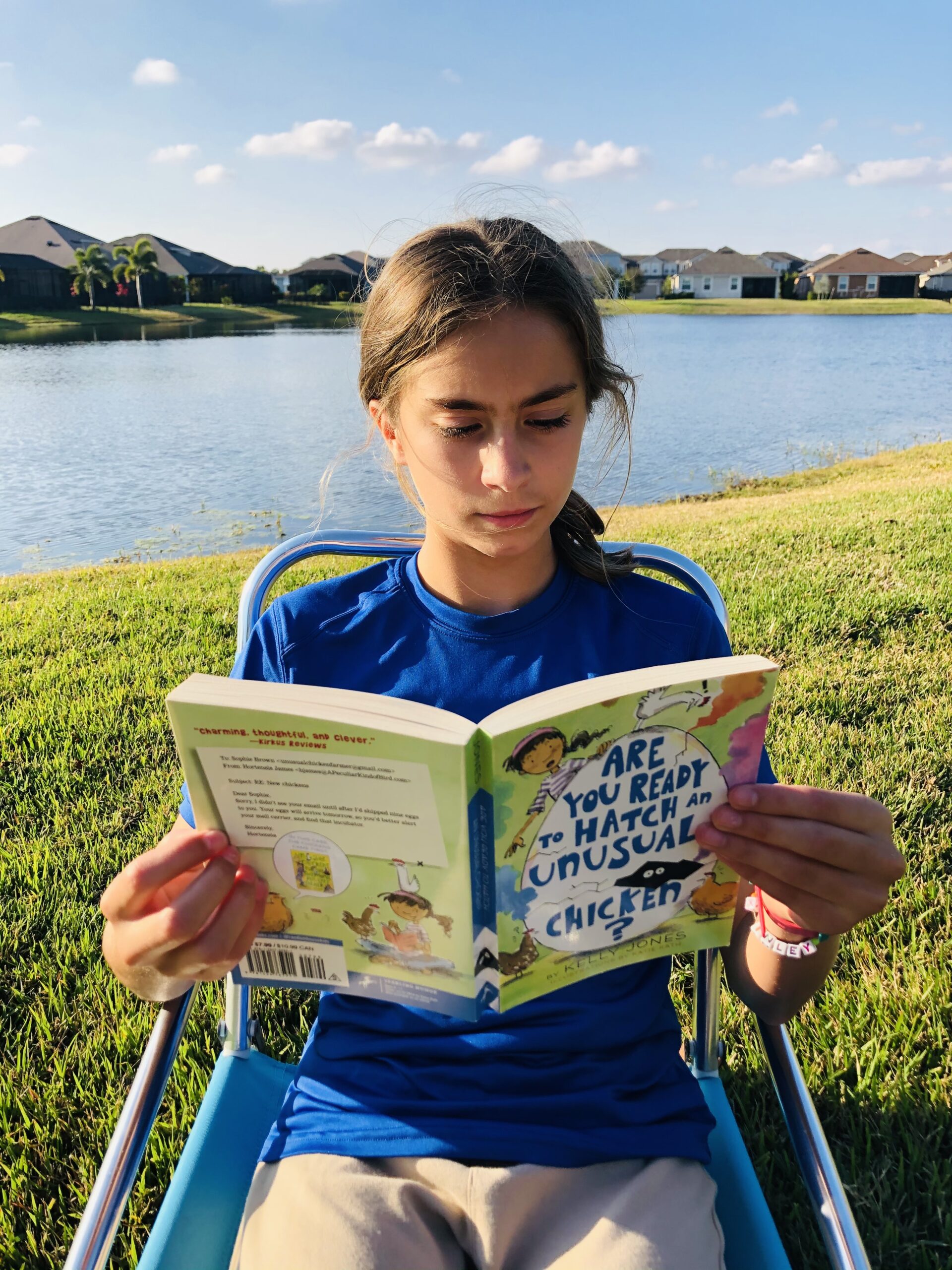 A girl reading a book for the book review on Ae you Ready to Hatch an Unusual Chicken?