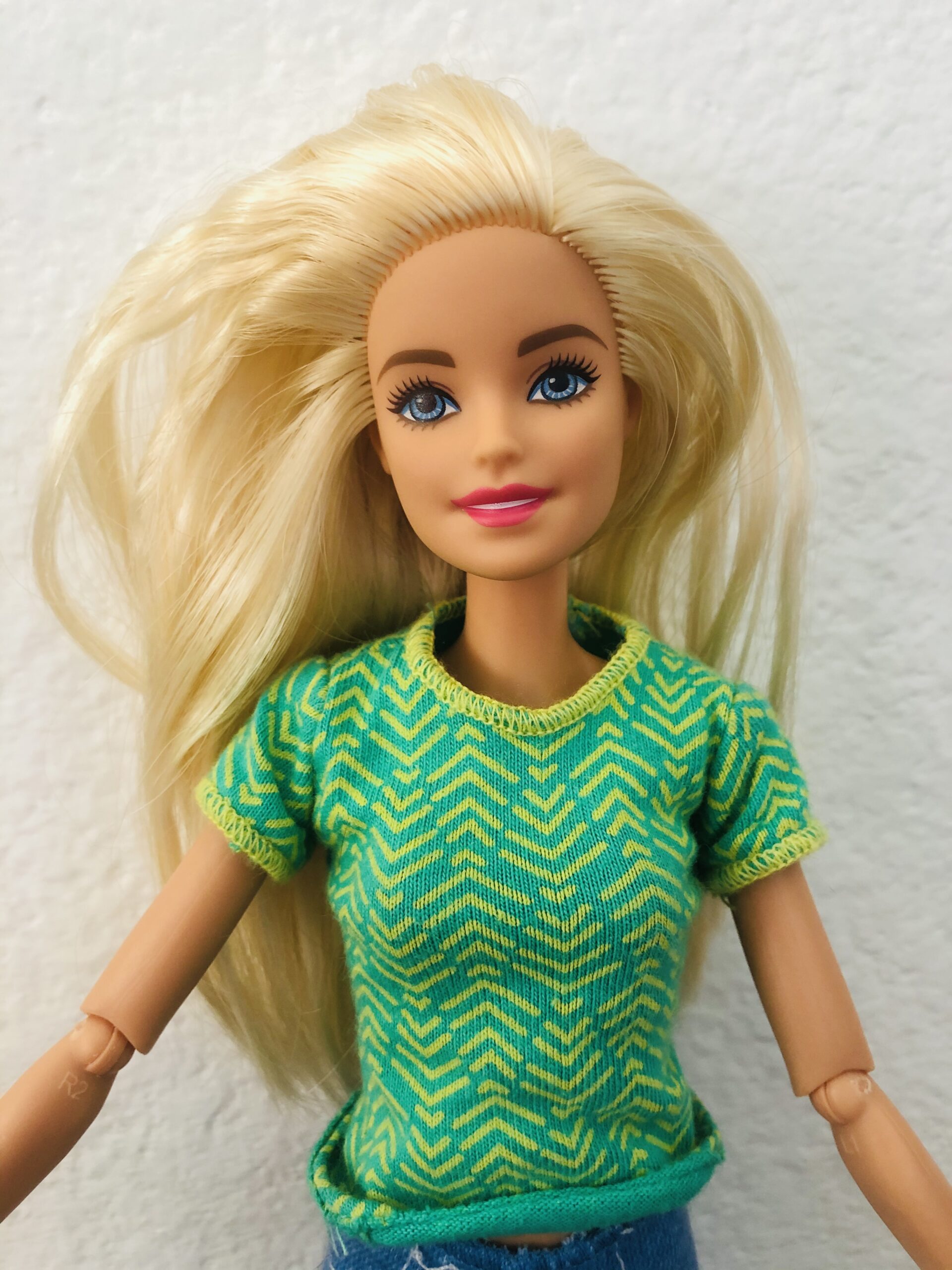A Barbie wearing a lime green and yellow shirt.