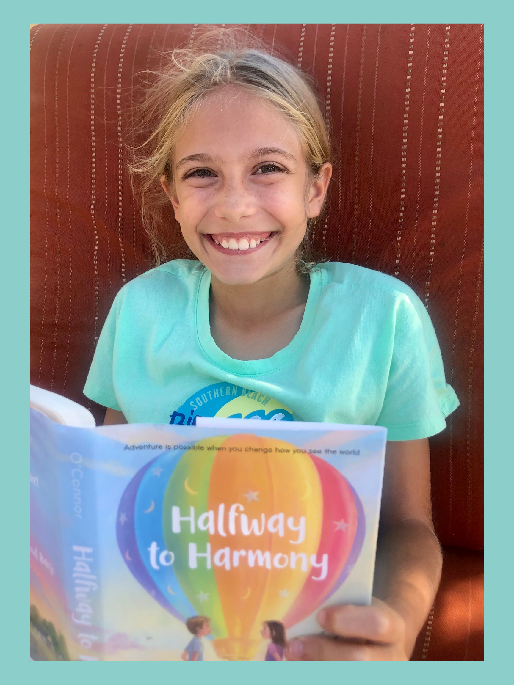 Girl smiling up while reading Halfway to Harmony. It's for the Kids Book Review.