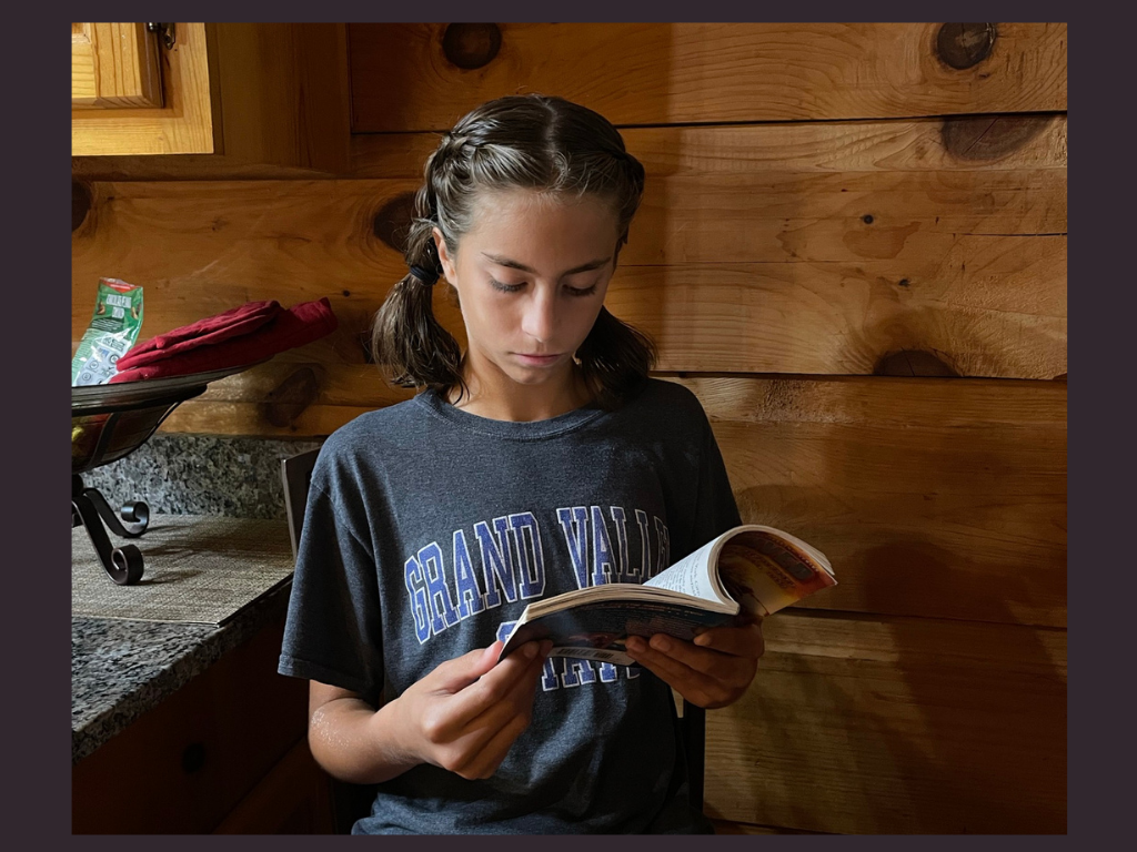 A girl reading a book for the I survived Book review by K and B Life