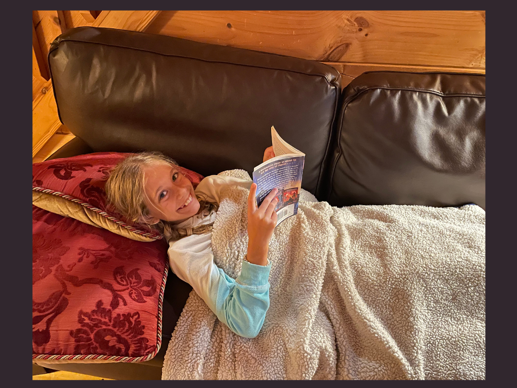 A girl reading on a couch.